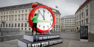 Greenpeace Austria built a giant installation, a 4 m high alarm clock, with a real alarm, and staged a protest by placing it in front of the government office in Vienna as a wake up call, a reminder of necessary environment protection.
Text on the book spine says: "100 days of governance: Time to wake up!"